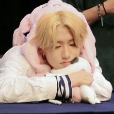 a man in a bunny costume sitting at a table with his hands on his chest