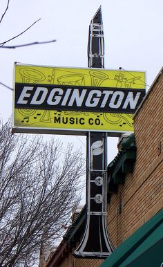 the sign for edgington music co is hanging from the side of a building