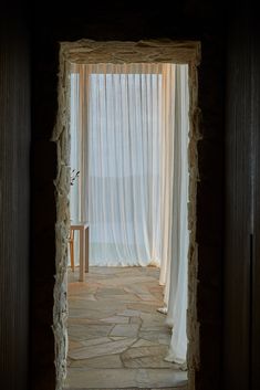 an open door leading into a room with sheer curtains