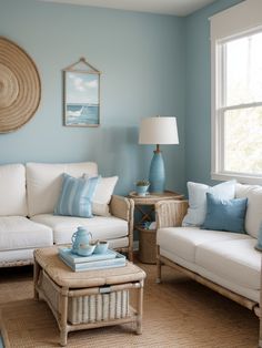 a living room with blue walls and white couches, coffee table and side tables