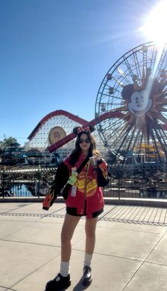 a woman standing in front of a ferris wheel