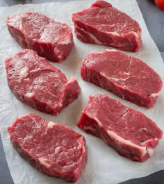 raw meat is laid out on top of the paper and ready to be cut into pieces