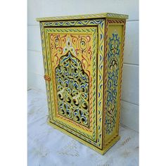 an ornately painted wooden box on a white surface