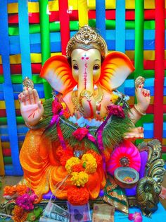 an elephant statue sitting on top of a table next to flowers and other items in front of it