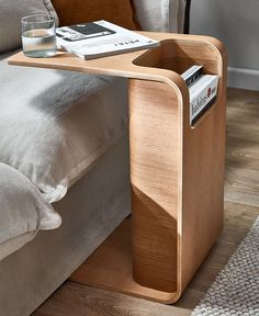 a wooden table with magazines on it next to a couch