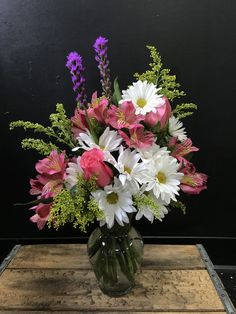 a vase filled with lots of pink and white flowers