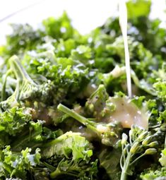 broccoli is being drizzled with dressing