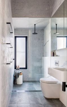 a bathroom with a white toilet sitting next to a window