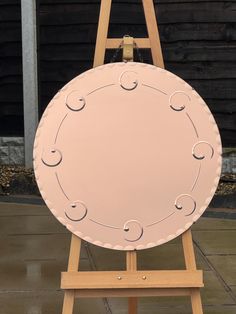 an easel with a pink circular sign on it