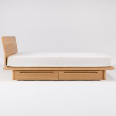 a bed with two drawers on each side and a white wall in the back ground