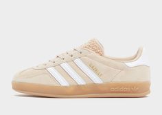 From The Courts To The Streets, Step Out In Adidas Originals Heritage With These Women's Gazelle Indoor Trainers. Landing In A Magic Beige Colourway, These Low-Profile Classics Have A Soft Suede Upper And A Textured Synthetic Tongue, While The Comfy Collar And Cushioned Insole Deliver A Smooth Ride. They're Sat Above A Translucent Gum 3 Rubber Outsole For Retro Vibes. Finished Off With White 3-Stripes On The Sidewalls And Gold Metallic Gazelle Branding Next To Them. | Ih5482. Material: Leather & Synthetic Upper/synthetic Sole Brown Adidas, Adidas Handball Spezial, Adidas Handball, 270 Nike, Baskets Adidas, 95 Nike, Uggs Outfit, Adidas Spezial, Adidas Campus