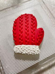 a red heart shaped cookie sitting on top of a table