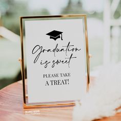 a graduation sign sitting on top of a wooden table