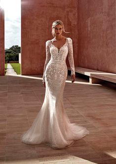 a woman in a wedding dress standing on a tile floor