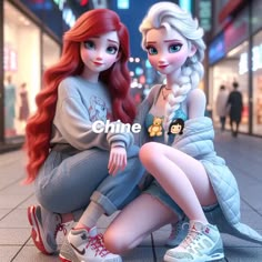 two dolls sitting on the ground in front of a building