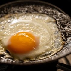 an egg frying in a skillet on top of a stovetop burner