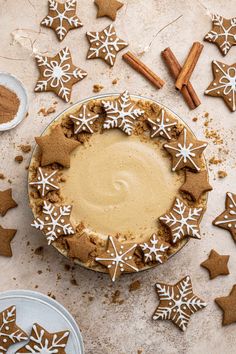 there is a pie with icing on it and some cinnamon sticks next to it