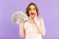 a woman in sunglasses holding money and making a funny face