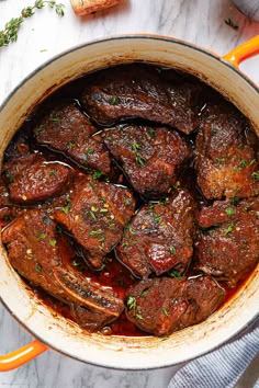 a pot filled with meat and sauce on top of a table