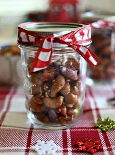 a jar filled with nuts on top of a red and white checkered table cloth