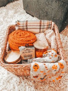 a basket filled with items sitting on top of a white rug next to a blanket