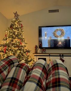 a living room with a christmas tree and television