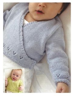 a baby wearing a blue sweater laying on top of a white bed next to a photo