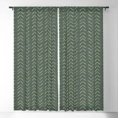 a green and white curtain with an arrow pattern on it in front of a wall