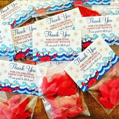 thank you bags filled with red candies on top of a wooden table next to other packaged candy