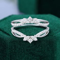 a diamond ring sitting on top of a green cloth