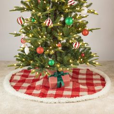 a small christmas tree with ornaments on it and a red checkered table cloth underneath