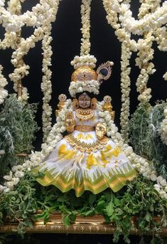 the statue is surrounded by white flowers and greenery