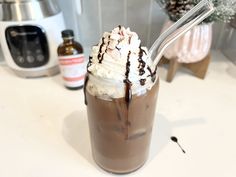 a chocolate milkshake with whipped cream on top and a straw in the cup