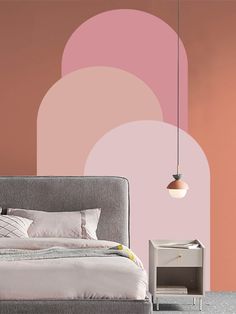 a bed sitting in front of a pink wall next to a night stand