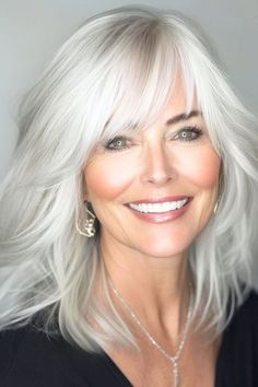 Save this pin for the best hairstyles for women over 60 with bangs. This light, airy cut is a game-changer for women with fine hair. Wispy layers create the look of fullness and movement, while soft bangs add a touch of whimsy. Layers In Back Of Hair, Mid Length Hair With Wispy Bangs, Hairstyles For Women Over 60 Medium, Top Hair Styles, Grey Transition, Fine Hair Bangs, Wispy Layers, 2015 Hair