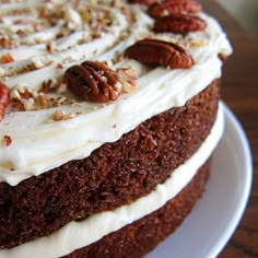 a cake with white frosting and pecans on top