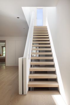 the stairs are made of wood and have white railings