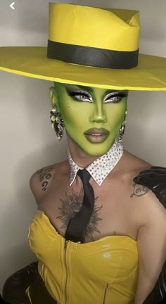 a woman wearing a yellow hat and green makeup