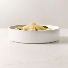 a white bowl filled with food on top of a table