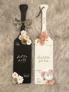 two wooden tags with flowers on them sitting on a furnishing floor next to each other