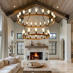 a living room with a large chandelier hanging from the ceiling over a fire place