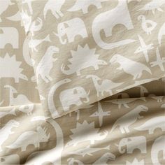 an elephant and giraffe pattern is shown on this sheet set, which has been made with organic linens