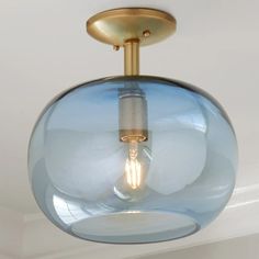 a light fixture with a glass ball hanging from it's center point in a room