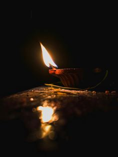 a lit candle sitting on top of a wooden table