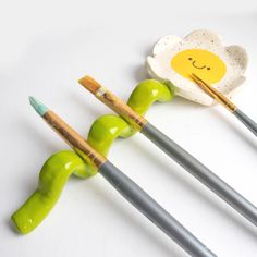 three chopsticks with painted faces on them