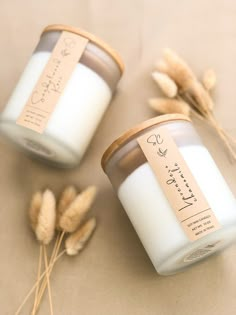 two candles sitting next to each other on top of a table covered in dry grass