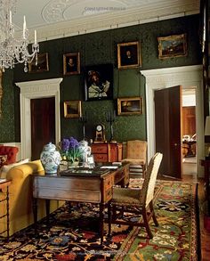 a living room filled with furniture and a fire place next to a wall covered in wood paneling