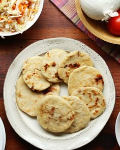 several flat breads are on a plate next to some vegetables