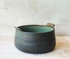 a black bowl sitting on top of a wooden table