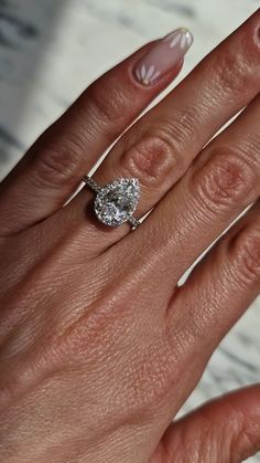 a woman's hand with a diamond ring on it